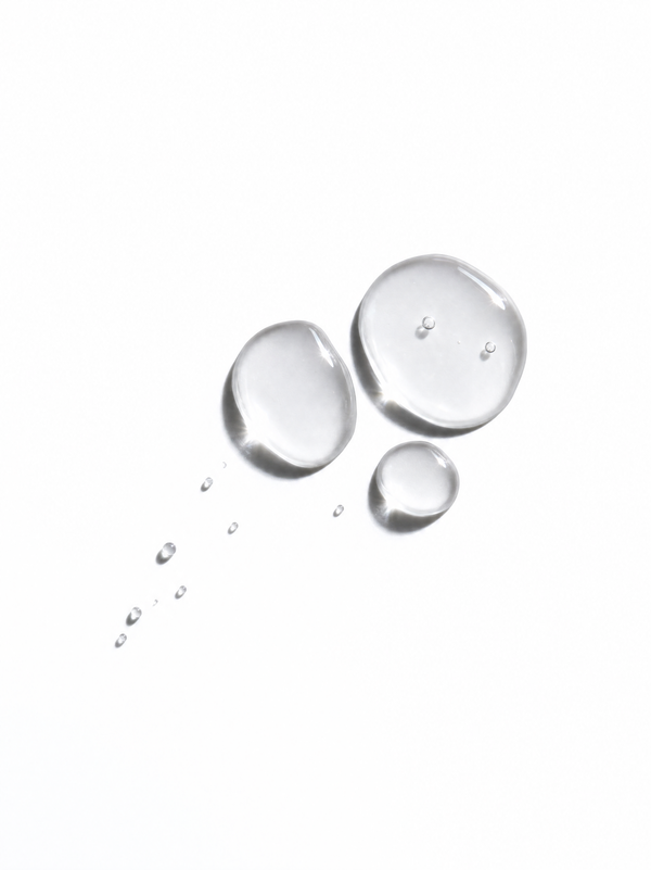 Immaculate Alpha Arbutin 2% Face Serum texture swatch - clear serum drops on a white surface